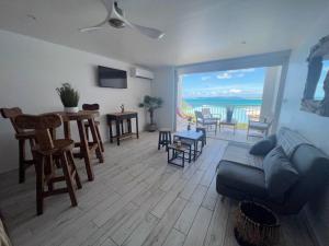 a living room with a couch and a view of the ocean at Studio Epoustouflante Vue Mer St Martin in Saint Martin