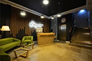 a living room with a green couch and a staircase at Stay inn Hotel Gdańsk in Gdańsk