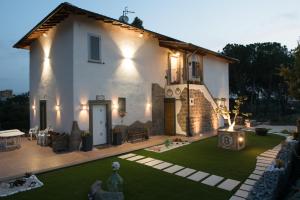 una gran casa blanca con un patio con césped en Le terrazze di casa Bonelli, en Vetralla