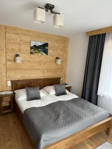 um quarto com uma cama grande e uma cabeceira em madeira em Willa Mango em Zakopane