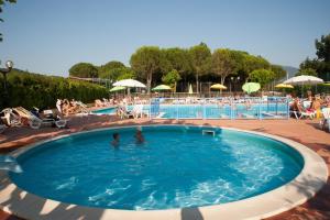a large swimming pool with people in the water at Green Village Assisi in Assisi