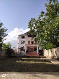 a white house with a fence and a yard at Himalayan Breeze Homestay in Srinagar