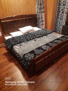 a large wooden bed in a room at Himalayan Breeze Homestay in Srinagar