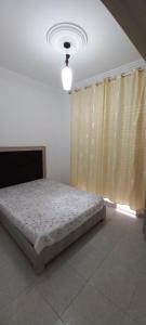 1 dormitorio con 1 cama en una habitación con ventana en Dar lbhar, en Kelibia