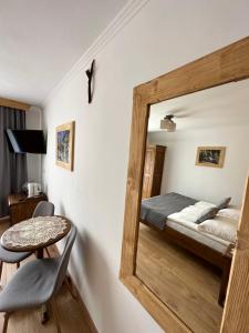 um espelho num quarto com uma cama e uma mesa em Willa Mango em Zakopane