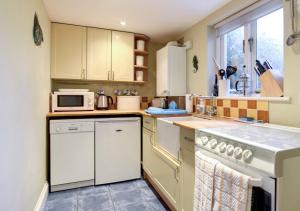 a kitchen with white appliances and a window at Avalon in Aldeburgh