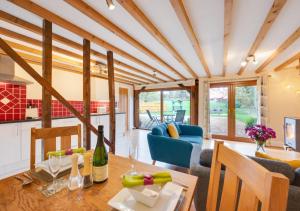 a kitchen and living room with a table and chairs at Hawkeswade Barn in Ufford