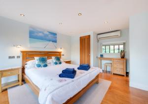 a bedroom with a large bed with blue pillows on it at Hawkeswade Barn in Ufford