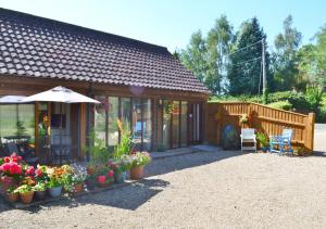 a house with an umbrella and some plants and flowers at Hawkeswade Barn in Ufford