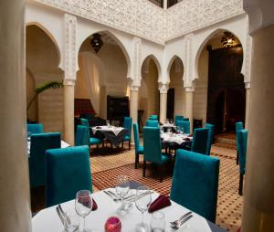 a dining room with tables and blue chairs at Riad Casa Lalla in Marrakech