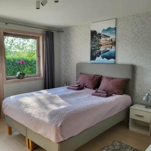 een slaapkamer met een groot bed en een raam bij Glomma House in Kongsvinger