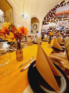 a dining room table with a black plate and flowers on it at Apartma Rešer in Črna na Koroškem