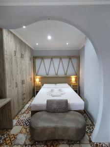 a bedroom with a large bed and a large ottoman at VILLA KALDERA in Skiathos Town