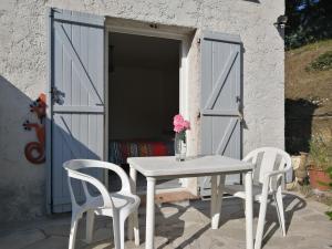 una mesa blanca y dos sillas frente a una puerta en Chez Isabelle en Saint-Paul-de-Vence