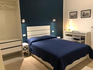 a bedroom with a bed and a blue wall at Kalé Atenea in Agrigento