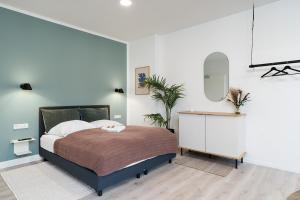 1 dormitorio con 1 cama grande y espejo en FLATLIGHT: Hildesheim Angoulemeplatz, en Hildesheim