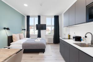 een keuken met een bed en een wastafel in een kamer bij FLATLIGHT: Hildesheim Angoulemeplatz in Hildesheim