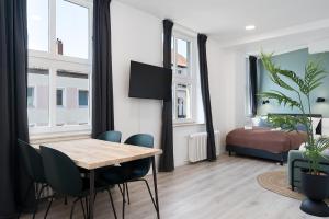 a dining room with a table and chairs and a bedroom at FLATLIGHT: Hildesheim Angoulemeplatz in Hildesheim