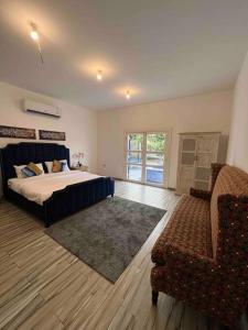 a bedroom with a bed and a couch and a chair at ALWADI Chalet - Khorfakkan in Khor Fakkan