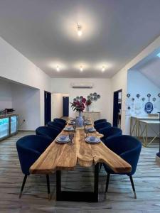 - une grande table en bois avec des chaises bleues dans l'établissement ALWADI Chalet - Khorfakkan, à Khor Fakkan