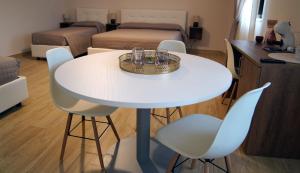 a white table and chairs in a room with a bedroom at B&B I Greci in Vairano Patenora