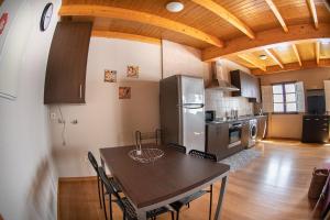 eine Küche mit einem Tisch mit Stühlen und einem Kühlschrank in der Unterkunft Apartamento Tiver in Ribadeo