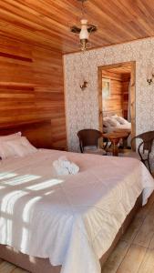 a bedroom with a large bed and a table at Cabanas Por do Sol in Urubici