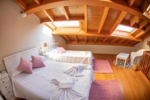 1 Schlafzimmer mit 2 Betten und Holzdecke in der Unterkunft Apartamento Tiver in Ribadeo