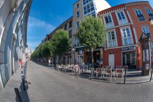 eine Stadtstraße mit Tischen und Stühlen auf einem Bürgersteig in der Unterkunft Apartamento Tiver in Ribadeo