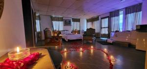 a large room with a bed and a room with candles at Hotel Royalty in Riobamba