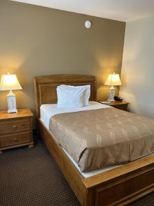 a bedroom with a bed and two night stands with lamps at The Admiral Hotel/Motel in Ocean City