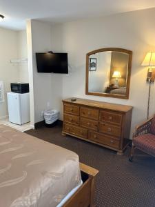 een hotelkamer met een bed, een spiegel en een dressoir bij The Admiral Hotel/Motel in Ocean City