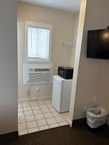 a kitchen with a refrigerator and a window at The Admiral Hotel/Motel in Ocean City