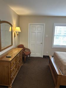 a bedroom with a bed and a dresser and a mirror at The Admiral Hotel/Motel in Ocean City