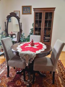 a dining room table with two chairs and a red and white table cloth at TeriTara in Čačak