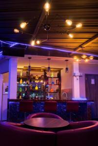 a bar in a room with red chairs and lights at Hotel Royalty in Riobamba