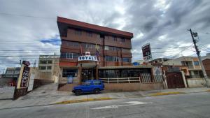 a blue truck parked in front of a building at Hotel Royalty in Riobamba