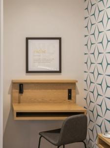 a desk with a chair and a picture on a wall at Kasa Niche Hotel Redwood City in Redwood City