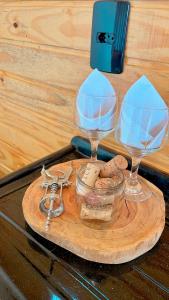 a wooden cutting board with two wine glasses and a jar at Cabanas Por do Sol in Urubici