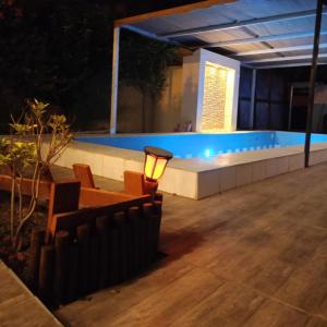 una piscina por la noche con luz en el patio en استراحة شرفة الواحةOasis Terrace Inn and Lounge, en Bahlāʼ