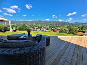 a deck with furniture and a view of the mountains at Valley House in Notodden