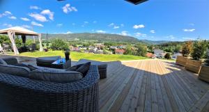 un patio con sofás y sillas en una terraza de madera en Valley House en Notodden