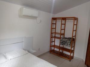 a bedroom with a bed and a book shelf at Bangalô 7b Praia de Guaratiba in Prado +8 photos