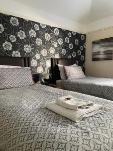 um quarto com 2 camas e um papel de parede preto e branco em Nettleton Country House em Nettleton