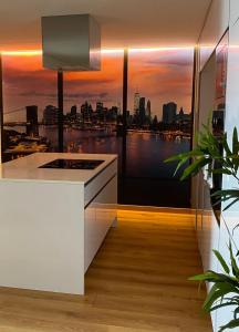 a kitchen with a view of a city skyline at Comfortable bedrooms in apartment with river view in Almada