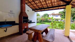 - une cuisine avec une table en bois et une cuisinière dans l'établissement Residencial Recanto da Lagoa - Praia de Taperapuan, à Porto Seguro