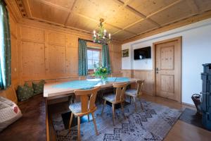 a dining room with a wooden table and chairs at Scheibenwald Hütte in Kössen