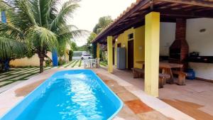 - une piscine en face d'une maison dans l'établissement Residencial Recanto da Lagoa - Praia de Taperapuan, à Porto Seguro