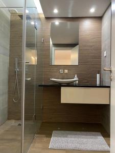 a bathroom with a sink and a glass shower at Comfortable bedrooms in apartment with river view in Almada