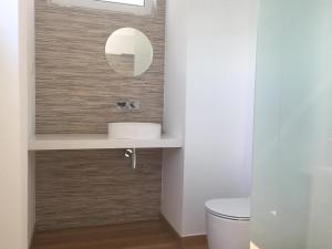 La salle de bains est pourvue d'un lavabo et d'un miroir. dans l'établissement Comfortable bedrooms in apartment with river view, à Almada